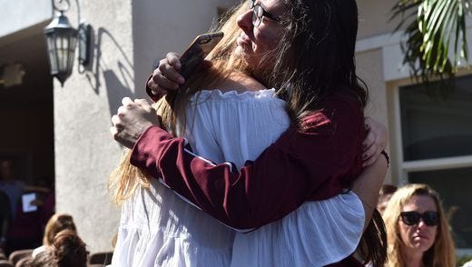 Friends embrace prior to a vigil for the victims of a Florida high school shooting.