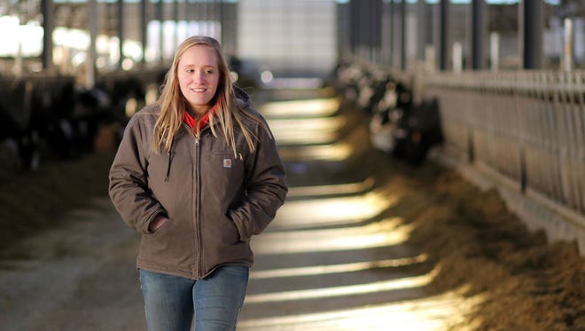 In this Dec. 7, 2017 photo, Chippewa Valley Technical College student Katelynn Monson walks through one of the cattle barns  at Denmark Dairy in Colfax, Wis.  Increasingly, the folks caring for the cows, monitoring their health and managing the herd are women, according to agriculture educators in west-central Wisconsin. The animal science management program at Chippewa Valley Technical College has seen female applicants climb from a minority four years ago to about three-quarters of the total for 2018-19, according to program director Adam Zwiefelhofer.