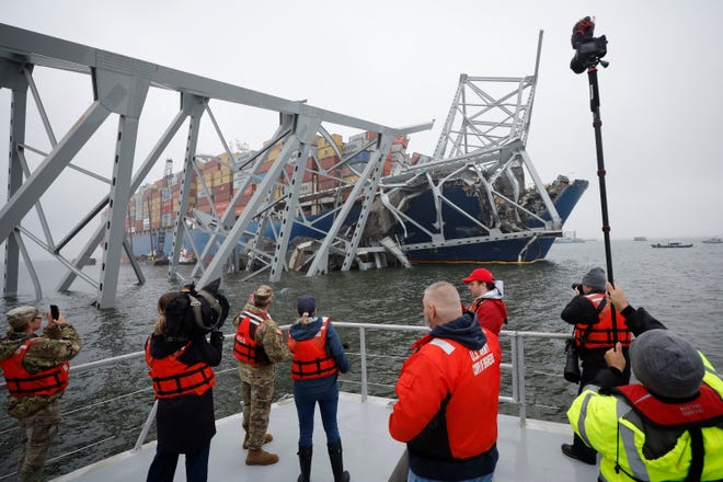 Media crews capture images of the wreckage of the cargo ship Dali after it crashed into and collapsed the Francis Scott Key Bridge, on April 2, 2024 in Baltimore, Maryland. A work crew was fixing potholes on the bridge, which is used by roughly 30,000 people each day, when the cargo ship struck in the early morning of March 26.