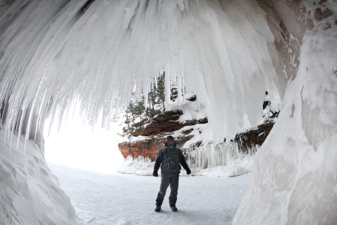 2014. A visitor to the Apostle Island Ice Caves takes in the natural beauty in solitude.
