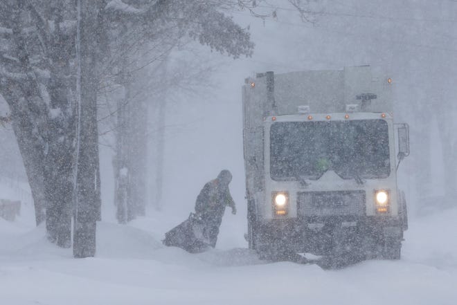 An employee of Pozorski Hauling & Recycling collects trash during a snowstorm on the 1100 block of 13th Street on Monday, Jan. 28, 2019, in Manitowoc, Wis.
