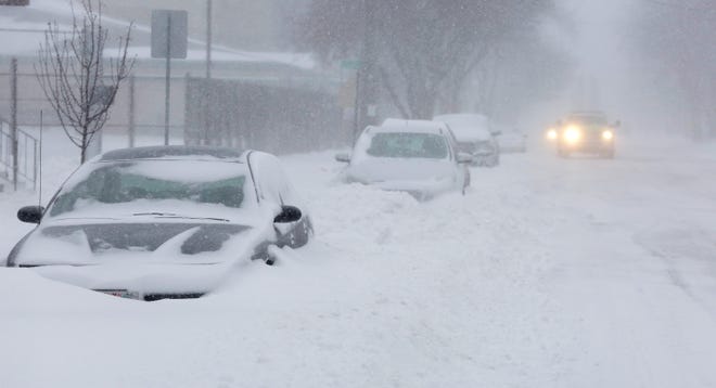 Cars are buried  in snowbanks on South Eighth Street on Monday, Jan. 28, 2019, in Sheboygan, Wis.