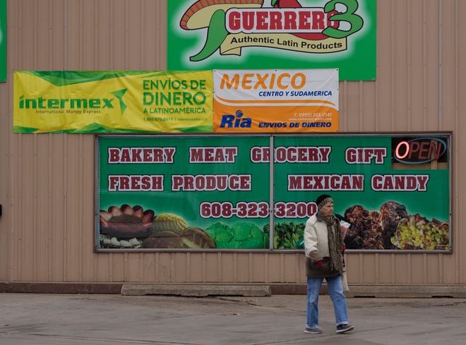 A pedestrian walks past one of a number of businesses that cater to Mexican immigrants in Arcadia in western Wisconsin.