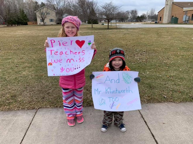Addison and Paxton Brester made signs to greet Pier Elementary School staff as they drove by in their car parade held Tuesday, March 24, 2020.