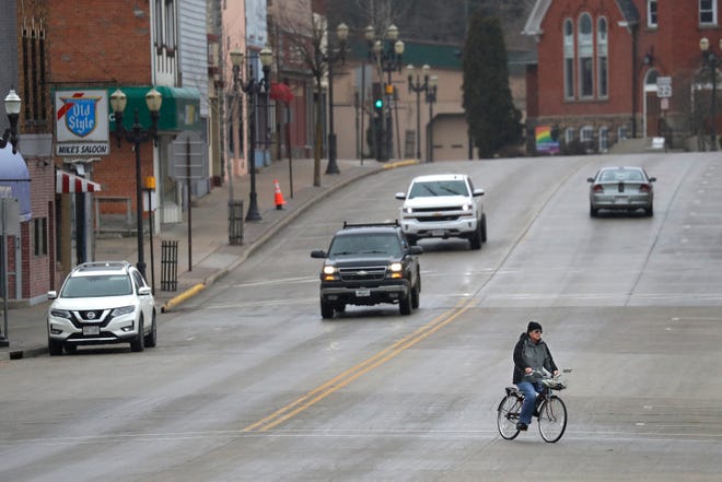 A bicyclist works his way along a quiet Main Street in the late afternoon Wednesday, March 25, 2020, in downtown Clintonville, Wis. 
Dan Powers/USA TODAY NETWORK-Wisconsin