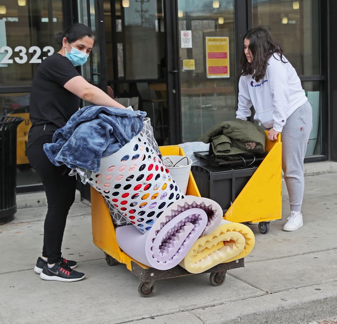 Rano Atambaeua of Kenosha, left, helps move her daughter Sevinch Atambaeua out of the UW-Milwaukee Cambridge Commons dormitory in March. How students live in dorms will likely look much different in the fall.