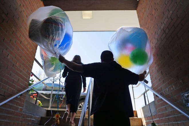Winkie's employee Jack Stuhlmacher carries a  balloon order to the car for Chana Bassman, left, of Milwaukee, who was picking them up for her nephew's birthday party, at Winkie's Toys & Variety in Whitefish Bay on Tuesday.