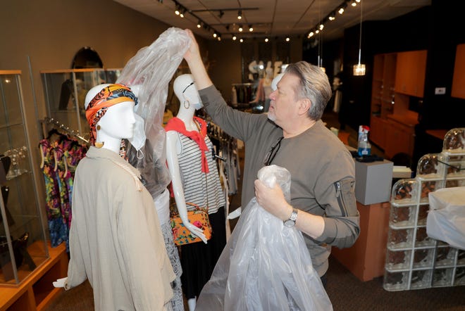 Michael Kruczynski, owner of New Options Salon and Boutique, removes protective plastic from mannequins shortly after reopening his shop  on East Silver Spring Drive in Whitefish Bay on Tuesday.  As of May 11, standalone or strip mall-based retail stores can offer in-person shopping, as long as customers are limited to five at a time and social-distancing guidelines are followed, Gov. Tony Evers announced Monday.