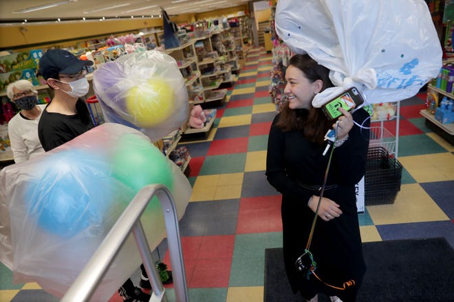 Chana Bassman, right, of Milwaukee, picks up a balloon order for her nephew's birthday party with help from employee Jack Stuhlmacher and Winkie's owner Beth Stuhlmacher at Winkie's Toys & Variety in Whitefish Bay on Tuesday.
