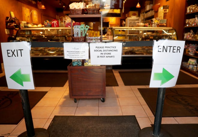 Signs inform customers to social distance at Amy's Candy Kitchen in Cedarburg on Wednesday. Aside from take-out orders, the shop's interior had been closed to customers before Monday due to the coronavirus.  As of Monday, stand-alone or strip mall-based retail stores can offer in-person shopping, as long as customers are limited to five at a time and social-distancing guidelines are followed, Gov. Tony Evers announced.