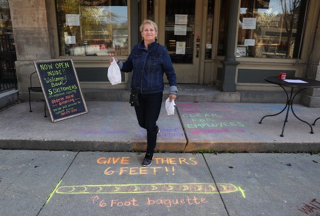 After making a purchase, Betty Hoefs of Mequon walks out of Boulangerie Du Monde bread and pastry shop on Washington Avenue in Cedarburg on Wednesday.  Aside from take-out orders, the shop's interior had been closed to customers before Monday due to the coronavirus. As of Monday, stand-alone or strip mall-based retail stores can offer in-person shopping, as long as customers are limited to five at a time and social-distancing guidelines are followed, Gov. Tony Evers announced.