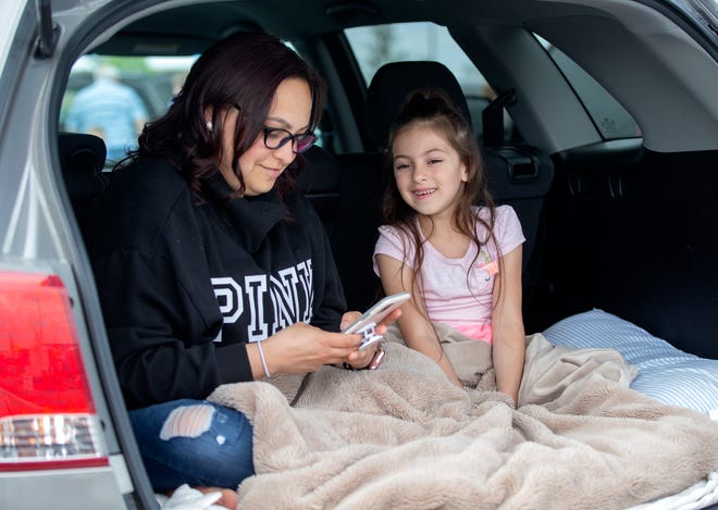 Monique Christensen, left, sits in the hatch with her daughter Lilly Christensen, 6, while waiting for the movies to start. Lilly Christensen said she was excited to see a drive-in movie.