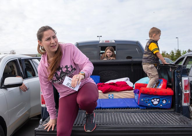 Kim Groshek, left, gets out of her truck while her son Josh Groshek, 3, right, jumps on his seat and her daughter Bella, 8, looks through the back window.