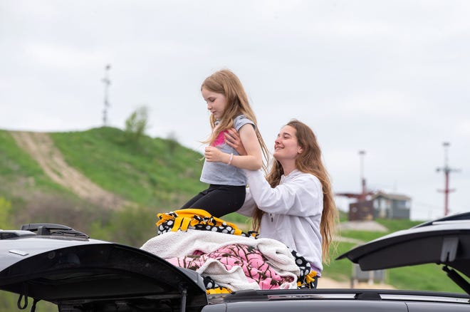 Breeanna Bartoshevich, right, holds up her sister Brynnley Dawes, 7, on the top of their car before the movie starts. " Abominable " was screened first followed by " Fast & Furious Presents: Hobbs & Shaw.