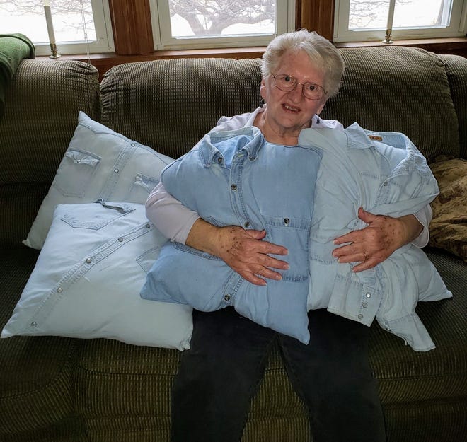 Susan holds some of the pillows made from Bob’s work shirts.