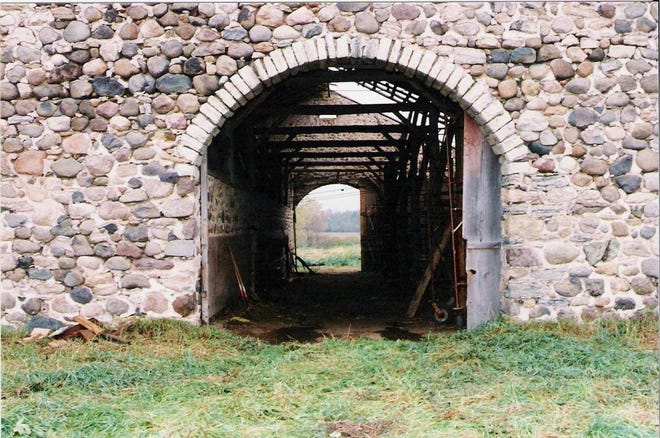 The barn measures 100 feet long by 60 feet wide. The walls are two feet thick and are estimated to weigh 2 tons per linier foot. The barn was designed with two large arched doorways so you could enter through one end with a wagon full of loose hay, unload the hay into the loft, and then drive out the other end.